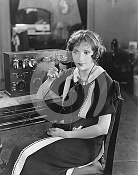 Switchboard operator sitting at telephone switchboard and talking