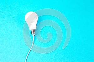 A Switched on light bulb on a light blue background - a symbol of a new idea, innovation