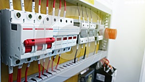 Switches in fusebox. Many black circuit brakers in a row in position OFF and one red switch in position ON. 3d illustration