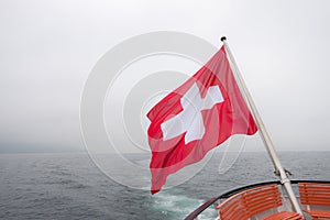 Switzerland flag over Lucerne or Luzern lake with heavy fog cove