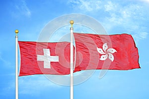 Switzerland and Hong Kong two flags on flagpoles and blue sky photo