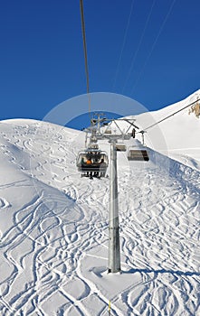 Switzerland, Samnaun, skiers sitting on ski lift