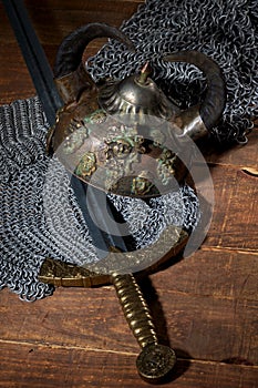 Sword and the soldier's helmet with horns on a wooden background