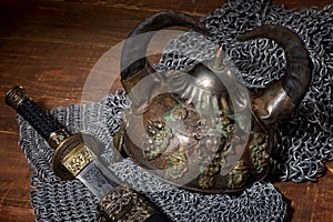 Sword and the soldier's helmet with horns on a wooden background