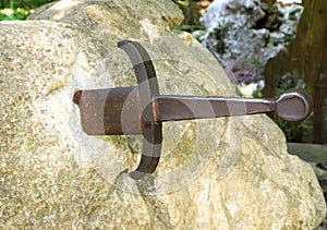 sword in the stone in the middle of the forest of trees symbol o