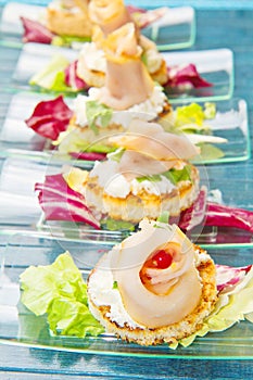 a glass dish with swordfish canape