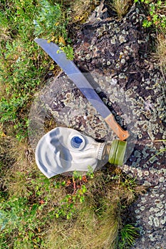 Swords gas mask on a stone in the summer dry grass nearby