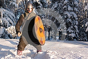 Swordsman in the winter forest in historical armor