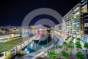 Sydney Harbour Bridge at night and CBD buildings on the foreshore in NSW Australia