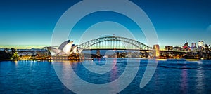 Sydney Harbour Bridge Panorama night view of City Skyline of NSW Australia bright neon lights reflecting off the wate