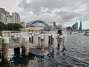 Sydney\'s harbour foreshore set against the famous Sydney Harbour bridge on a cloudy overcast day photo