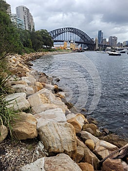 Sydney\'s harbour foreshore set against the famous Sydney Harbour bridge on a cloudy overcast day photo