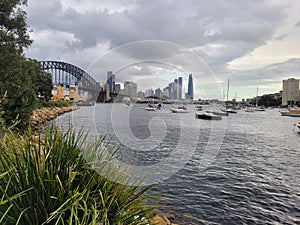 Sydney\'s harbour foreshore set against the famous Sydney Harbour bridge on a cloudy overcast day photo