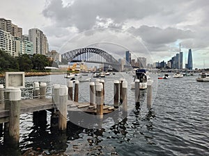 Sydney\'s harbour foreshore set against the famous Sydney Harbour bridge on a cloudy overcast day