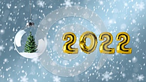 Symbol 2022 made of gold balloons with Christmas bauble decoration. Minimal Christmas or New Year concept