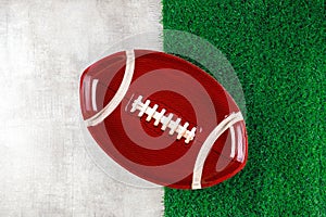 Symbol of american football ball plate on white and green background