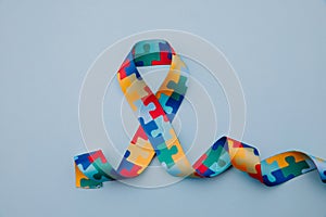 Symbol of autism with Puzzle pattern ribbon on blue background