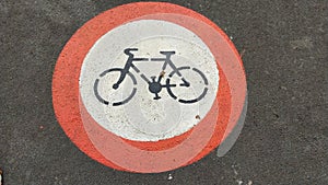 Symbol of a bicycle in red circle printed onto sidewalk depicting this is a zone forbidden for riding bicycle