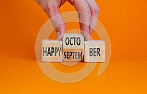Symbol for the change from September to October. Businessman turns cubes and changes words `Happy September` to `Happy October