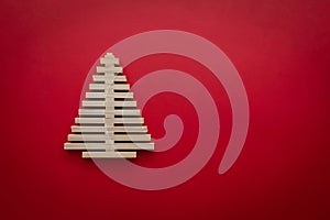 symbol Christmas tree from a wooden on red background. Empty copy space for your greetings