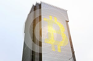 A symbol is depicted on the glass surface of the building - bitcoin