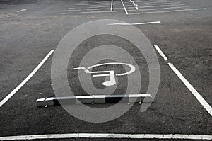 Symbol of disabled parking car on black asfalt floor photo