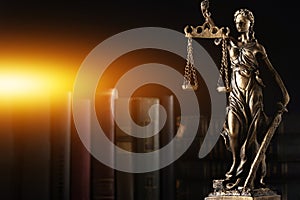Symbol of fair treatment under law. Statue of Lady Justice and books on dark background, space for text