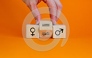 Symbol for gender equality. Hand turns a cube and changes a unequal sign to a equal sign between symbols of men and women.