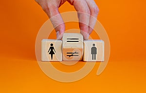 Symbol for gender equality. Hand turns a cube and changes a unequal sign to a equal sign between symbols of men and women.