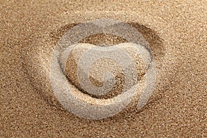 symbol of heart is drawn on clean sand