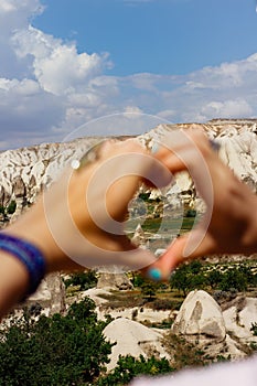 Symbol of heart made up of womens fingers through it is seen Cappadocia