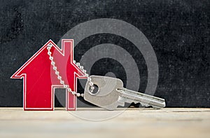 Symbol of the house with silver key on vintage wooden background