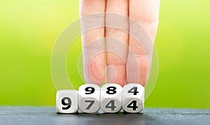 Symbol for the increase of the personal exemption in Germany. Hand turns dice and changes the amount 9744 Euro to 9984 Euro photo