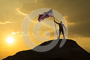 The symbol of a man with the flag of the United States of America stands on the top of the mountain.