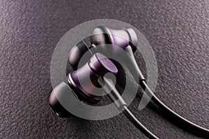 A symbol of the modern youth culture, sport, and technology, an image of a pair of earbuds on black background