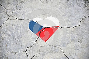The symbol of the national flag of Czech Republic in the form of a heart on a cracked concrete wall