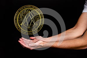 The symbol of the new popular cryptocurrency eosio with the image of hands