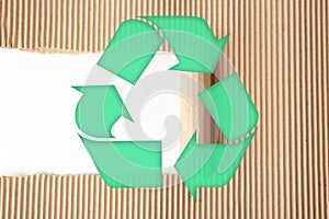 Symbol of recycling on ripped corrugated cardboard