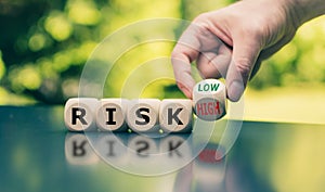 Symbol for reducing a risk. Cubes form the word `risk`