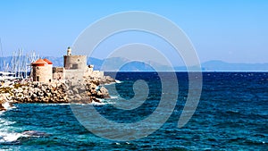 Symbol of Rhodes - windmill and fort of St. Nicholas in the port of Mandraki with sea view