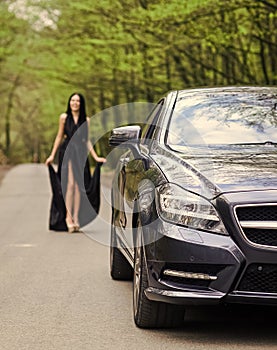 Symbol of richness. Rich people lifestyle. Start journey. Luxury car. Auto and pretty sexy woman at road. Travel concept