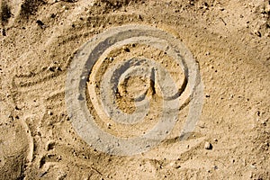 At symbol on sand
