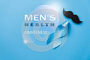 Symbol for support men. Top view on blue Ribbon with mustache for supporting people living and illness. Healthcare