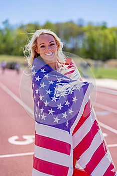 Symbol of Triumph: Proud American Athlete Honors Nation with Flag Display