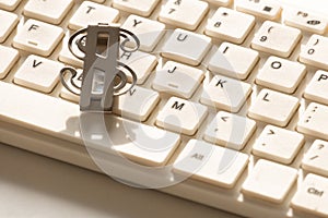 The symbol of the US dollar lies on a white keyboard for a computer. Close-up. Background for design on the theme of financial