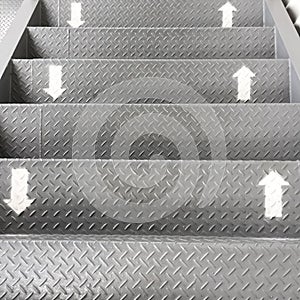 The symbol of the way up and down on the stairs. The arrows were painted in white on the stainless steel ladder. It is direction