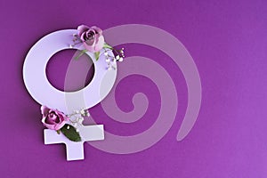 symbol of women\'s day cut out of paper with flowers on purple background