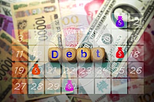 A symbol with the words Debt on a dice placed on the banknote and calendar backgrounds