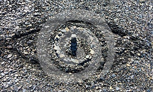 Symbolic eye made out of stones and carved sand on a summer pebble beach - Concept of big brother or omnipresence of God photo