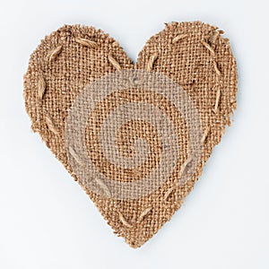 Symbolic heart of burlap lies on a white background